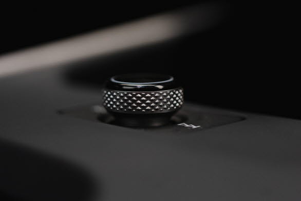 Mellan förvaringsfacket för smarta telefoner och dryckeshållarna sitter ett vridreglage för styrning av volymen.