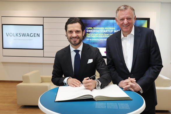 Prins Carl Philip skriver en hälsning i  Volkswagens gästbok. Till höger: Andreas Renschler, VD för TRATON SE och styrelseledamot i Volkswagen AG.